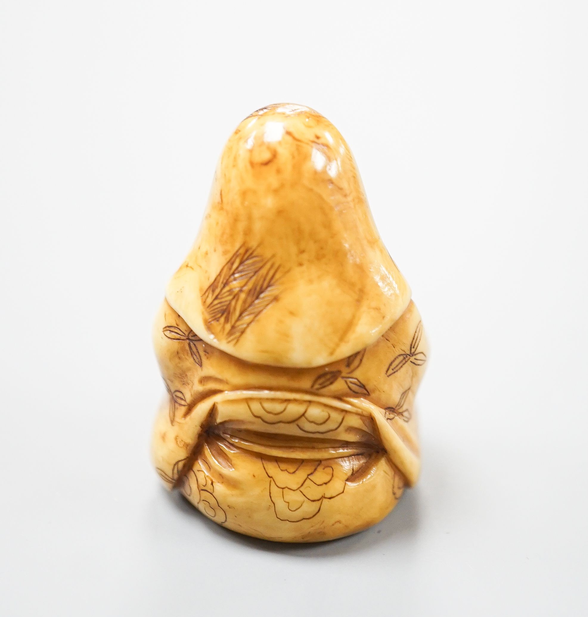 A Japanese ivory netsuke of Fukurokuju seated, holding a sceptre, early 20th century, 3.8cm
